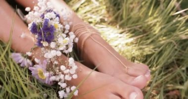 Yeşil çimen çiçekler ile kızın ayak