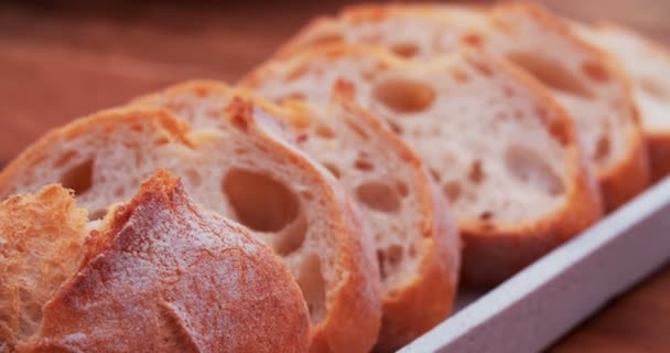 Fresh baguette lying on a vintage wooden board — Stock Video