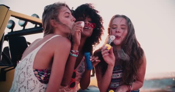 Kız arkadaşlar kabarcıklar günbatımında üfleme — Stok video