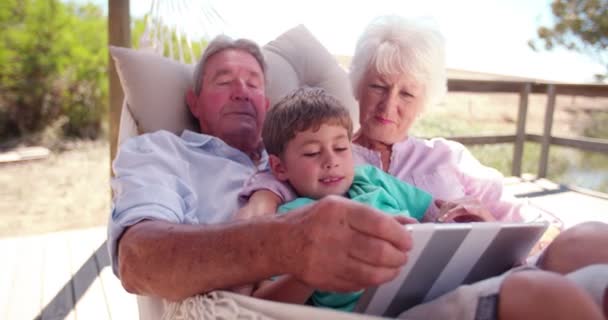 Παππούδες και γιαγιάδες και εγγονό τους, χρησιμοποιώντας μια ψηφιακή δισκίο — Αρχείο Βίντεο