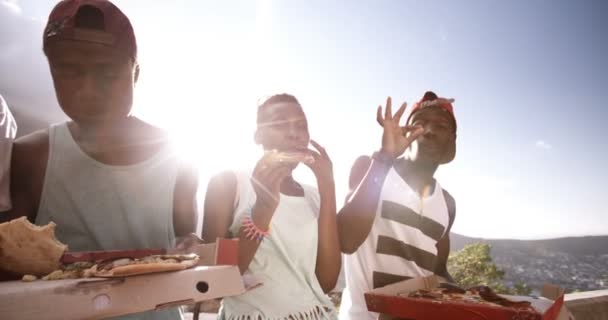 Freunde lachen zusammen, während sie Pizza teilen — Stockvideo