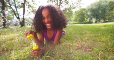 Afro kız parkta kabarcıklar üfleme