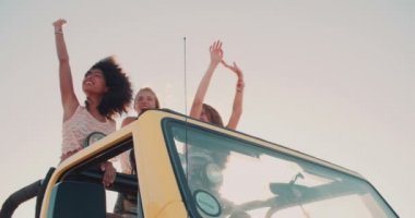 Afro kız ve arkadaşları kumsalda dans