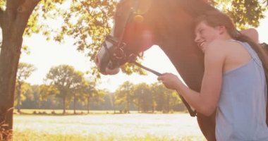 Atına sevgiyle yaslanan kız