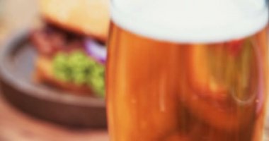 Rustik ahşap masada hamburger ve bira