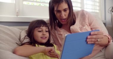 Anne ve kızı bir dijital tablet üzerinde oynama