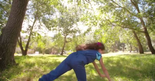 Mädchen macht Wagenrad in einem Rasenpark — Stockvideo