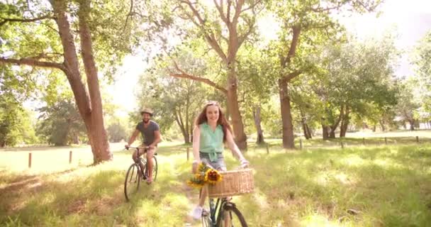 Pasangan bersepeda bersama di taman — Stok Video