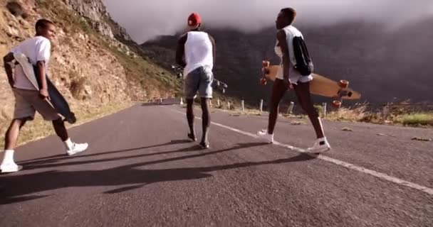 Teen skaters walking along a road — Stock Video