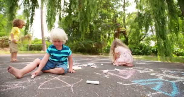 Дети рисуют меловые рисунки на дорожке — стоковое видео