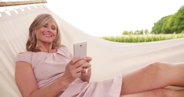 Volwassen vrouw met mobiele telefoon outdoors — Stockvideo