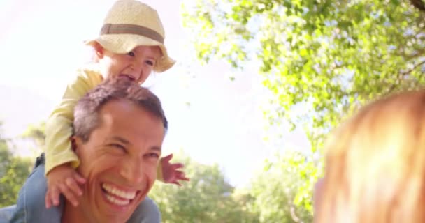 Father carrying daughter on shoulders with mom — Stock Video