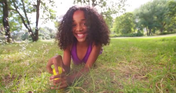 Afro girl blowing bubbles in park — Stock Video