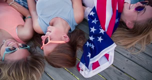 Adolescentes acostados con una bandera americana — Vídeos de Stock