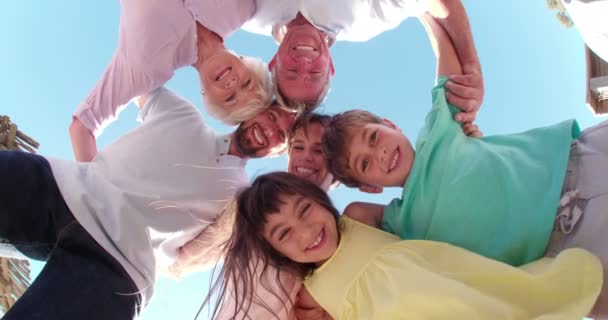 Три поколения семьи стоят в кругу улыбаясь — стоковое видео
