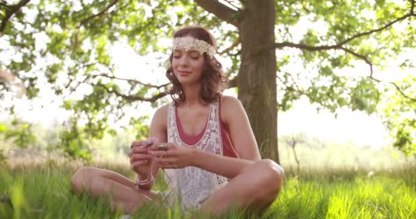 Ragazza hippie che annusa un fiore in un parco estivo — Video Stock