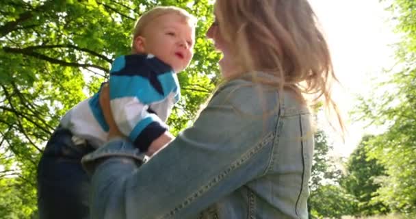 Mãe levantando menino no parque — Vídeo de Stock