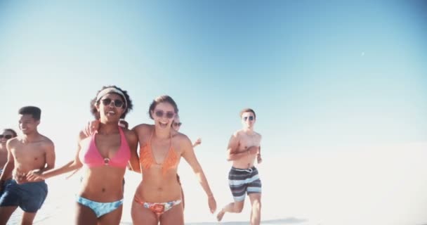 Друзья смешанных рас бегут по пляжу — стоковое видео