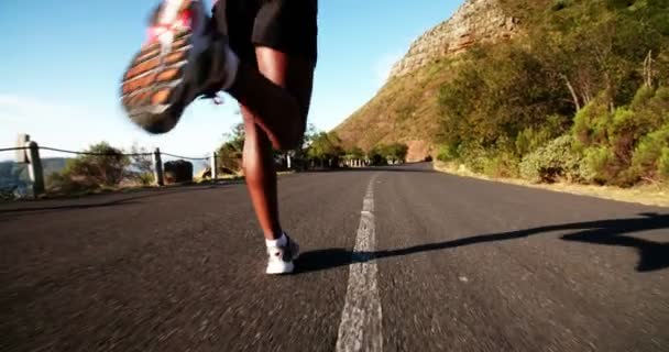 Jogger correndo ao longo da estrada da montanha — Vídeo de Stock
