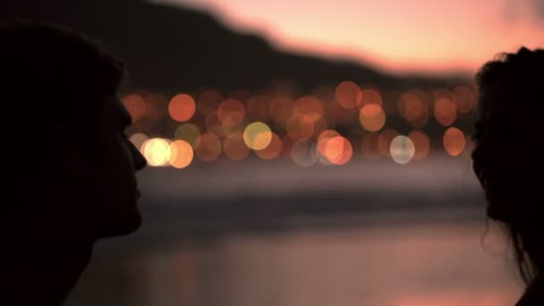 Silhouette of loving couple kissing on the beach — Stock Video