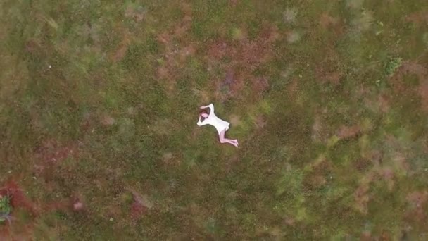 Teenage girl in boho fashion lying in grass — Stock Video