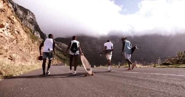 Patinador amigos caminando por carretera de montaña — Vídeo de stock