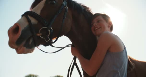 Chica sonriendo amorosamente a su caballo al aire libre — Vídeo de stock