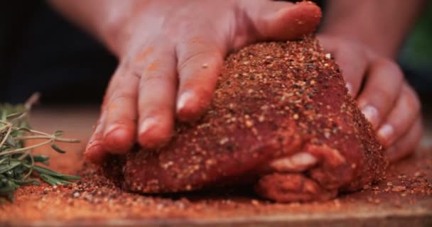 Condimento de hierbas y especias que se frotan en la carne de cerdo — Vídeo de stock