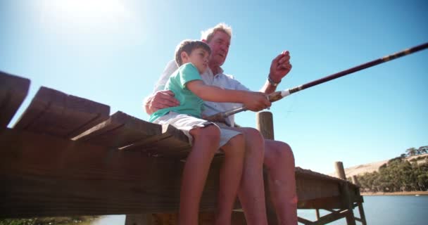 Retired grandfather teaching his grandson to fish — Stock Video