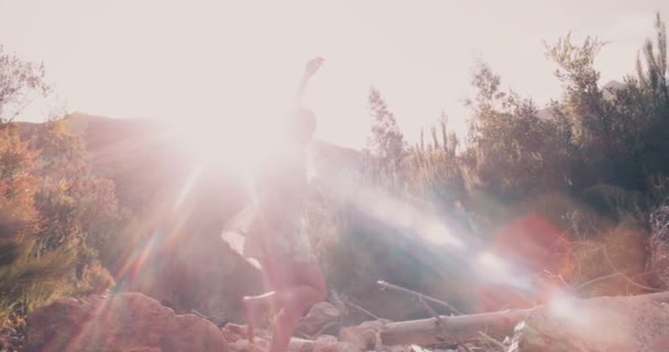 Девушка Бохо переступает через камни на озере — стоковое видео