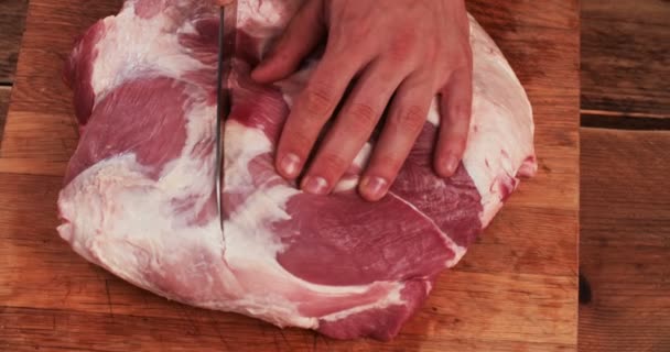 Gran pedazo de carne cruda en la superficie de madera que se corta — Vídeo de stock