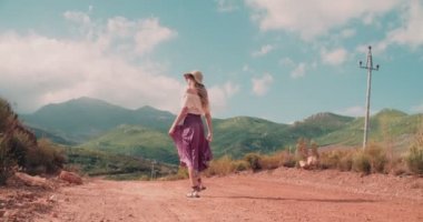 Dikiz ülke toprak yolda yürürken boho kız