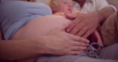 Annemin hamile karnıma dokunmaktan kanepede genç aile