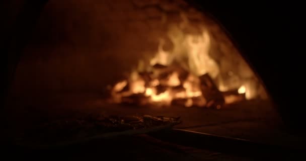 Pizza étant placé à l'intérieur du four à bois 