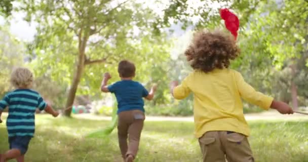 Crianças correndo no parque com bandeiras coloridas — Vídeo de Stock