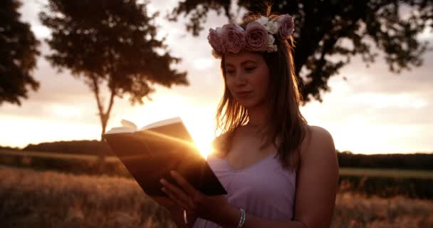 Chica con corona de flores leyendo un libro — Vídeos de Stock