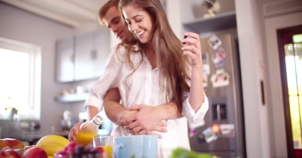 Woman pouring orange juice at breakfast table — Stock Video