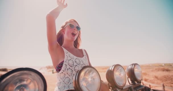 Blonde teenage girl waving on a road trip — Stock Video