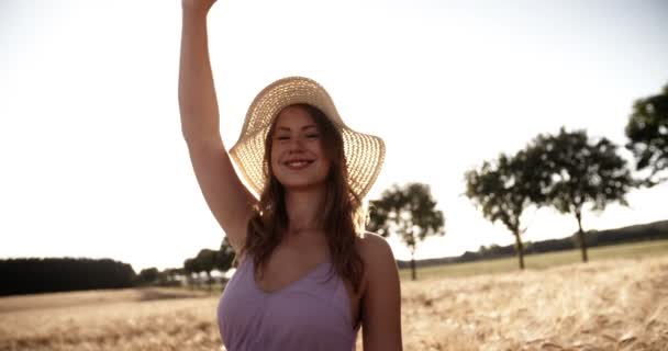 Девушка с воздушными шарами танцует на пшеничном поле — стоковое видео