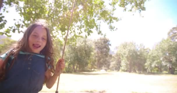 Niño balanceándose en un parque soleado — Vídeo de stock