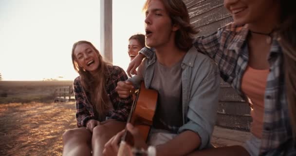 Teen ragazzo suonare la chitarra per gli amici — Video Stock