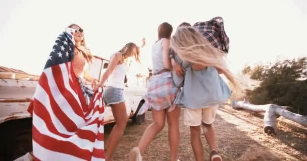 American teens walking with flag into sun flare — Stock Video