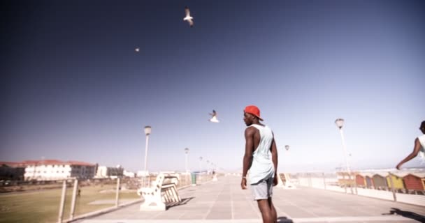 Afro guy terloops longboarding — Stockvideo
