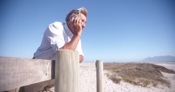 Senior retraité actif au téléphone à la plage — Video