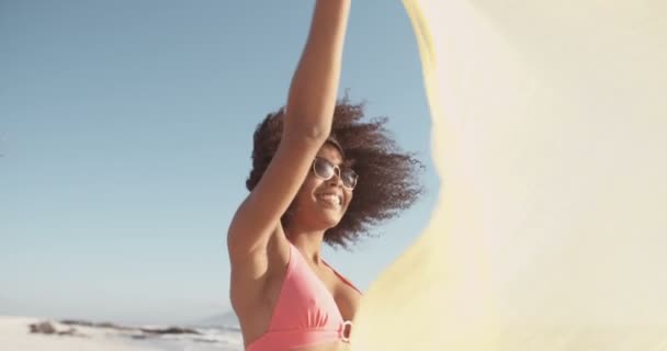 Afro chica volando un paño en un día de playa soleado — Vídeo de stock