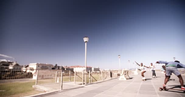 Afrikaanse Amerikaanse tieners longboarding op het strand — Stockvideo