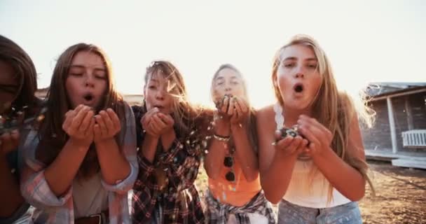 Teen φίλοι φυσώντας πολύχρωμα κομφετί — Αρχείο Βίντεο