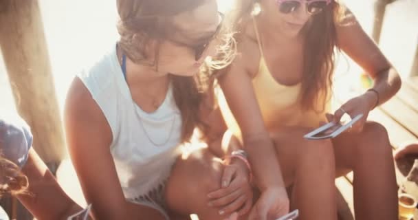 Chicas en la playa buscando fotos de su verano — Vídeo de stock