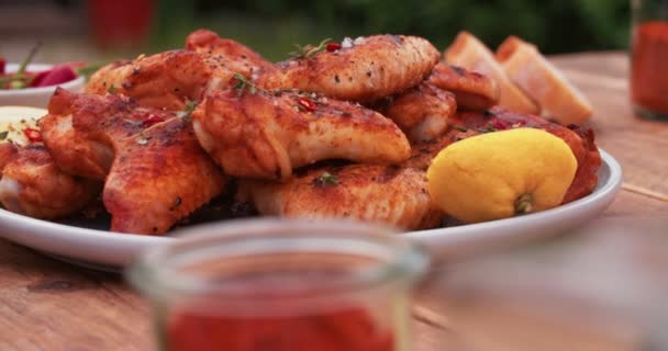 Plate of spicy chicken wings on a wooden table — Stock Video