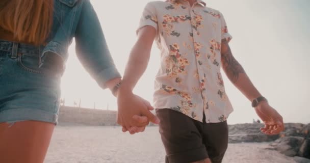 Estilo retro hipster pareja cogida de la mano en la playa — Vídeos de Stock